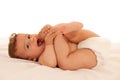 Hapy baby boy in playing on bed isolated over white