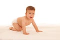 Hapy baby boy in playing on bed isolated over white