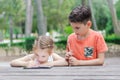 Hapy kids learn in a park. Brother and sister together do the j