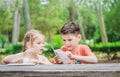 Hapy kids learn in a park. Brother and sister together do the j