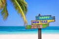 Hapy new year 2018 on a colored wooden direction signs, beach and palm tree