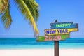 Hapy new year 2020 on a colored wooden direction signs beach and palm tree background