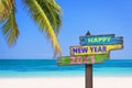 Hapy new year 2021 on a colored wooden direction signs beach and palm tree background