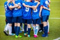 Hapy young football soccer team with coach standing together