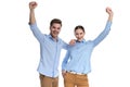 Hapy young winning couple standing with hands in the air