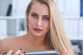 Beautiful young secretary hides her nakedness for a folder on an office background. Harassment concept. Royalty Free Stock Photo