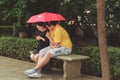 Couple under umbrella sitting on bench Royalty Free Stock Photo