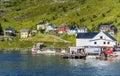 The harbor of Akkarfjord hamlet in the north of Soroya island as seen from the Sea. Village houses are at background Royalty Free Stock Photo