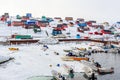 Harbor area with motorboats and colorful inuit houses in backgroung, Aasiaat city