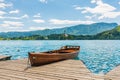 Harbor and boat on the Bled lake, Slovenia. Wooden boats on the pure blue water. Summer day near the Alps and forest Royalty Free Stock Photo