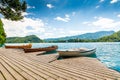 Harbor and boat on the Bled lake, Slovenia. Wooden boats on the pure blue water. Summer day near the Alps and forest Royalty Free Stock Photo