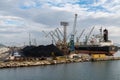 Harbor crane loading coal onto a freight ship in the industrial port of Ploce Royalty Free Stock Photo