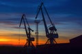 Harbor cranes and sky background during sunset. Royalty Free Stock Photo