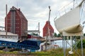 Harbor in DarÃâowo, Poland. Two old, brick, industrial buildings and dock machinery. In the foreground - yacht in the shipyard.