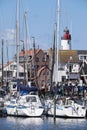 Harbor of small Dutch fishing town Urk with fishing and sailing boats and lighthouse Royalty Free Stock Photo