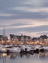 A harbor town at twilight. White accents for lights reflecting on the water