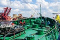 Harbor view with a closeup fragment of the green forward deck of a small ship