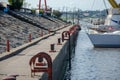 Harbor wall with red bollards and moored boats Royalty Free Stock Photo