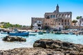 The harbour and beach at Cala San Vito, Puglia, Italy with rocks in the foreground