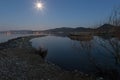 An harbour on a lake at dusk with star shaped moon Royalty Free Stock Photo