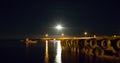 Harbour Lights with full moon rising at fishing harbor Royalty Free Stock Photo