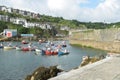 Harbour of small Cornish fishing village with houses in background Royalty Free Stock Photo