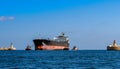 Harbour tugs assisting a large oil products tanker ship enter the port.