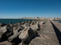 Harbour wall in Povoa de Varzim, Portugal with breakwater boulders and and city in distance Royalty Free Stock Photo