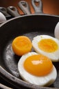 Hard boiled egg with fresh yoke in one half, all in cast iron skillets