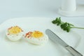 Hard boiled eggs sliced halves in white plate Royalty Free Stock Photo