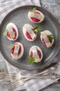 Hard-boiled eggs stuffed with beetroot salad and herring close-up in a plate. Vertical top view Royalty Free Stock Photo