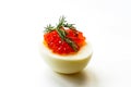 Hard-boiled sliced chicken egg half with red caviar and dill on white background Royalty Free Stock Photo