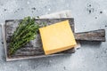 Hard cheese with knive on wooden cutting board. Parmesan. Gray background. Top view