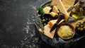 Hard cheese with olives and cheese knife on black stone background. Parmesan. Top view. Royalty Free Stock Photo