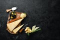 Hard cheese with olives and cheese knife on black stone background. Parmesan. Top view. Royalty Free Stock Photo