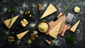 Hard cheese with olives and cheese knife on black stone background. Parmesan. Top view. Royalty Free Stock Photo
