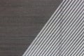 Hard diagonal shadows on grey textured wall from a window roller shutter or blinds. Attractive abstract half frame composition