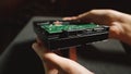 Hard disk drive close up. Female hands showing the underside of an HDD. Royalty Free Stock Photo