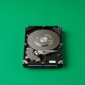 Hard disk drive on a green surface, showcasing the internal components. The shiny Royalty Free Stock Photo