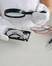 Hard disk drive through a magnifying glass, information search, diagnostics, restore concept vertical Royalty Free Stock Photo