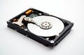 Hard disk drive removed from case against white background. Opened hard disk shows internal parts. Tech part for data storage and Royalty Free Stock Photo