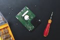 Hard disk drive and set of screwdriver at black background. repair hdd after diagnostics. data maintenance after virus attack Royalty Free Stock Photo