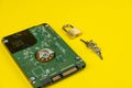 Hard drive on a yellow background with a lock and keys