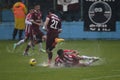 Hard football tackle on flooded field