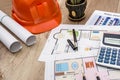 Hard hat with blueprints and rulers, pen, calculator on desk Royalty Free Stock Photo