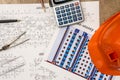 Hard hat with blueprints and rulers, pen, calculator Royalty Free Stock Photo