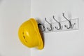 Hard hat hanging on white wall. Royalty Free Stock Photo