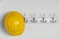 Hard hat hanging on white wall. Safety Royalty Free Stock Photo