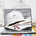 Hard hat, house plans and laptop