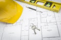 Hard Hat, Pencil, Level and Keys Resting on House Plans Royalty Free Stock Photo